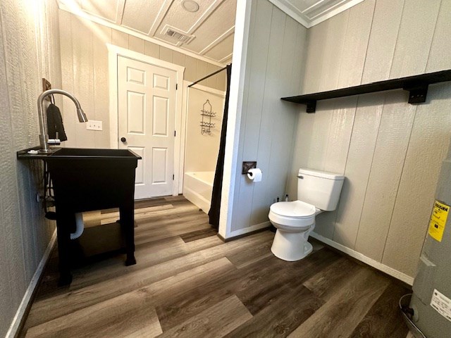 full bath with crown molding, wood finished floors, toilet, and shower / washtub combination
