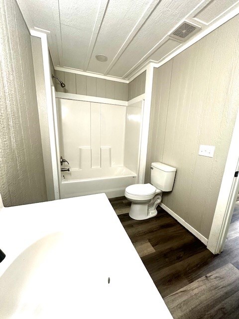 308 Pine, Diboll, TX 75941 - bathroom featuring visible vents, bathtub / shower combination, wood finished floors, baseboards, and toilet