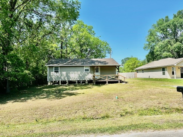 back of house with a lawn and a deck