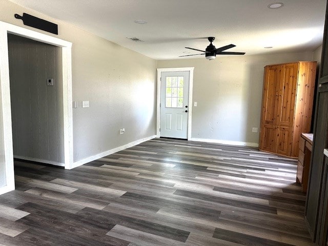 empty room with baseboards, ceiling fan, wood finished floors, and visible vents