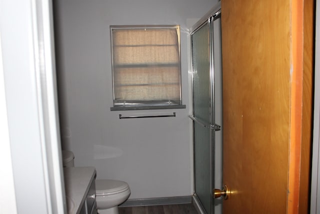 bathroom featuring hardwood / wood-style floors, vanity, toilet, and an enclosed shower