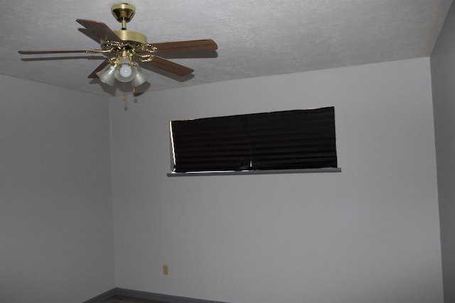 empty room featuring ceiling fan and a textured ceiling