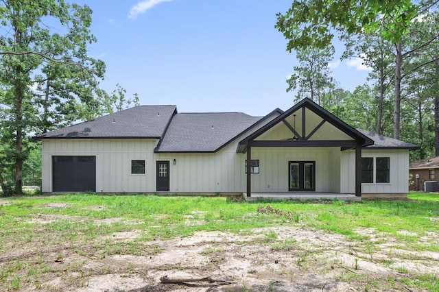 rear view of property with a yard and a garage