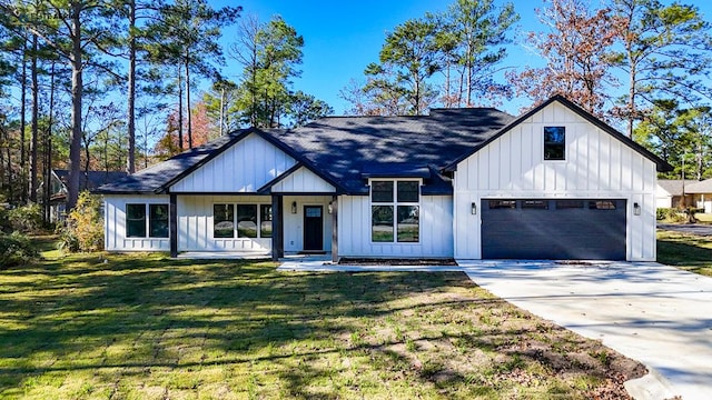 modern farmhouse style home with a front yard and a garage