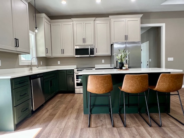 105 Cooper Rd, Zavalla, TX 75980 - kitchen featuring stainless steel appliances, light wood-style floors, a kitchen bar, a kitchen island, and recessed lighting