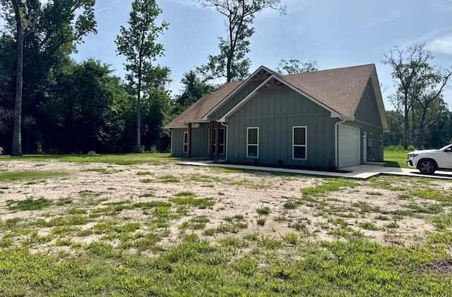 105 Cooper Rd, Zavalla, TX 75980 - view of property exterior featuring board and batten siding, an attached garage, a shingled roof, and driveway