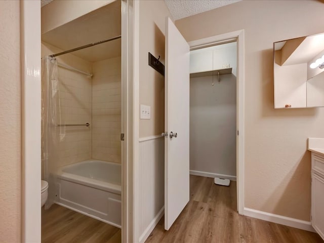 full bathroom with shower / bath combo, a textured ceiling, toilet, vanity, and hardwood / wood-style flooring