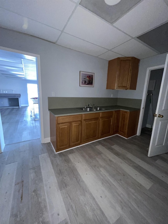 kitchen featuring a paneled ceiling, light hardwood / wood-style floors, and sink