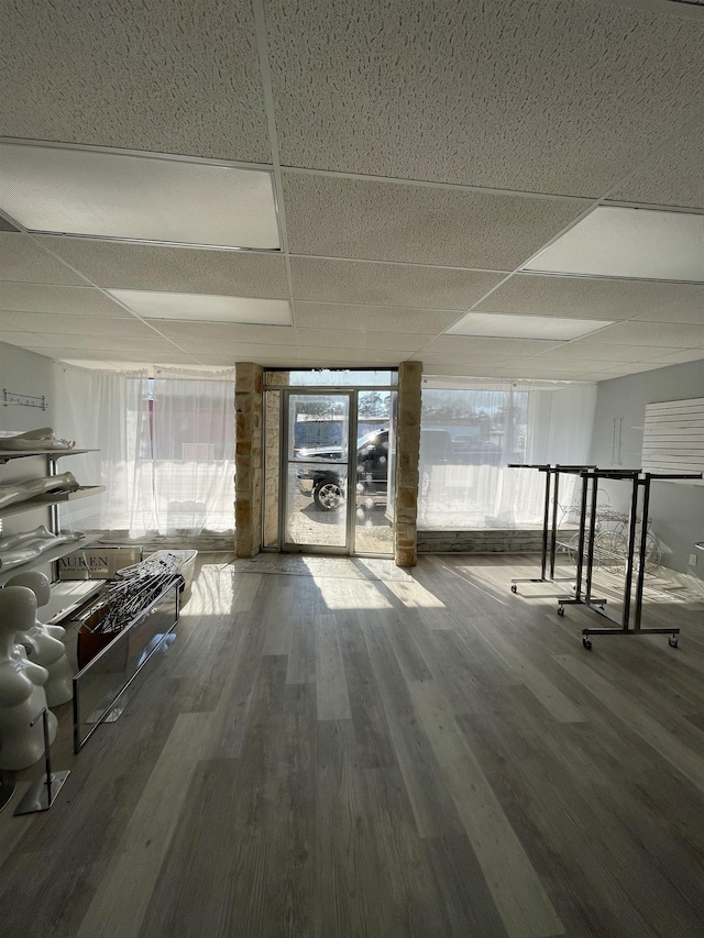 interior space featuring wood-type flooring and a drop ceiling