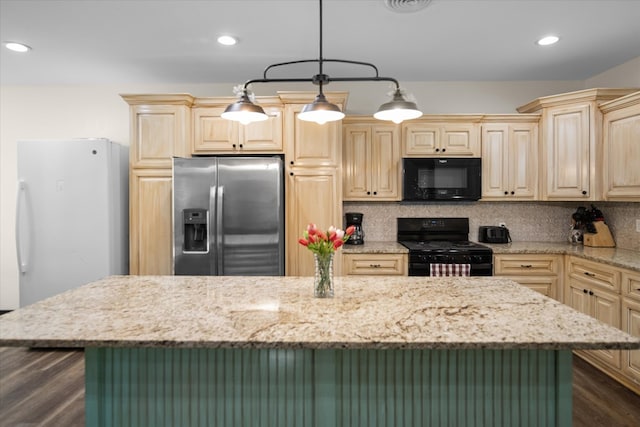 kitchen with tasteful backsplash, hanging light fixtures, a center island, and black appliances