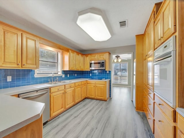 kitchen featuring light wood-style flooring, visible vents, light countertops, appliances with stainless steel finishes, and tasteful backsplash