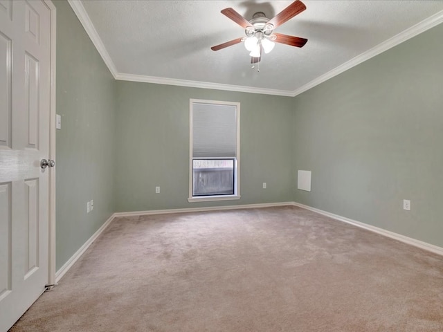 unfurnished room featuring a textured ceiling, baseboards, crown molding, and light colored carpet