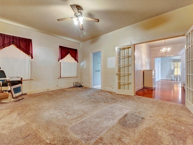 interior space featuring carpet, french doors, and ceiling fan with notable chandelier