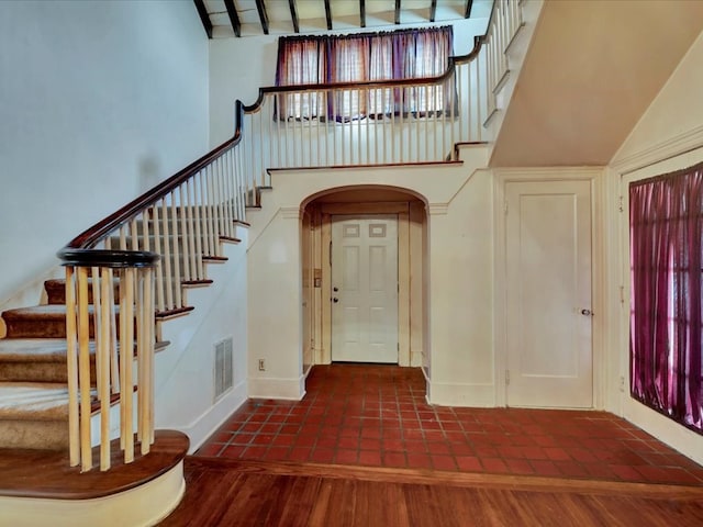 entryway featuring vaulted ceiling with beams and dark hardwood / wood-style flooring