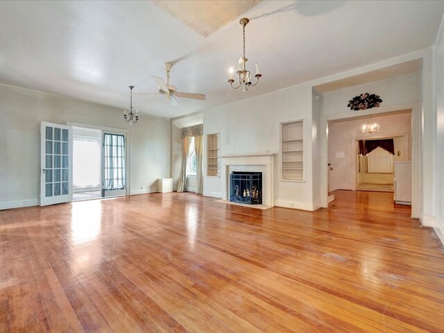 unfurnished living room featuring light hardwood / wood-style flooring and ceiling fan with notable chandelier