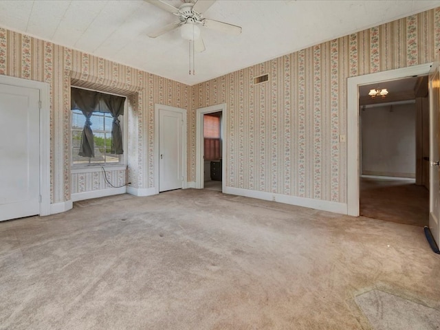 unfurnished bedroom with carpet flooring and ceiling fan with notable chandelier