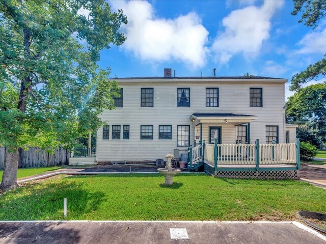 colonial house featuring a front lawn and a deck