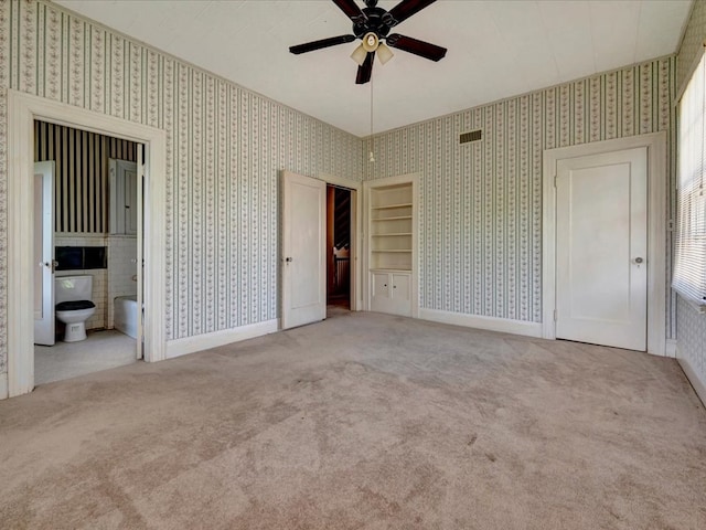 unfurnished bedroom featuring ensuite bathroom, ceiling fan, and light carpet