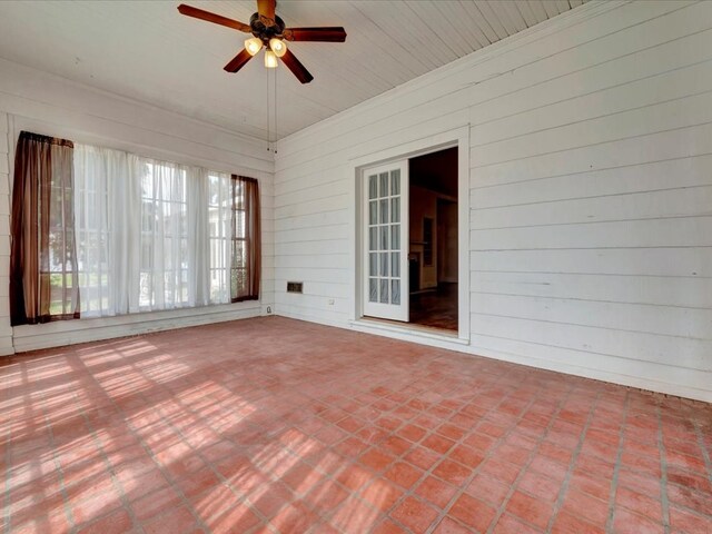 unfurnished sunroom with ceiling fan