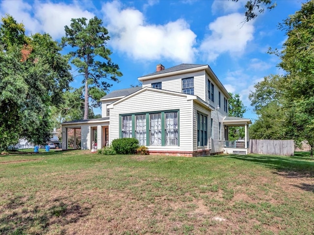 rear view of property featuring a lawn