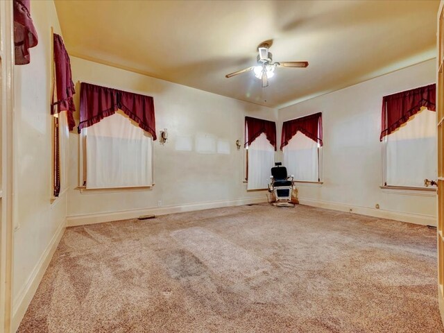 carpeted spare room with ceiling fan