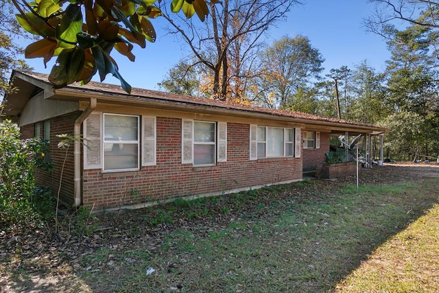 view of side of home featuring a yard and brick siding