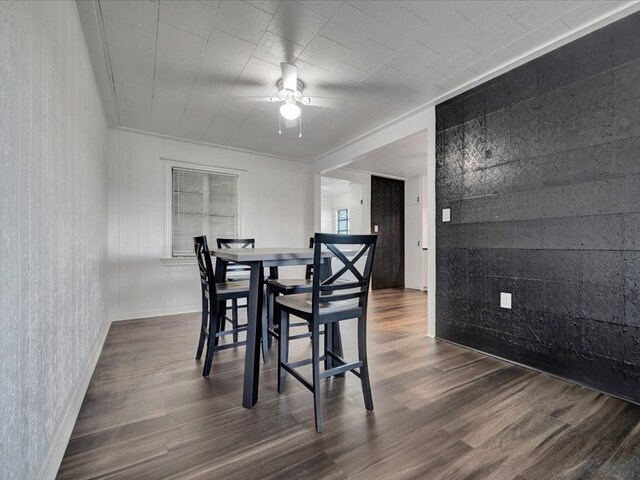 dining space with ceiling fan, ornamental molding, and dark wood-type flooring