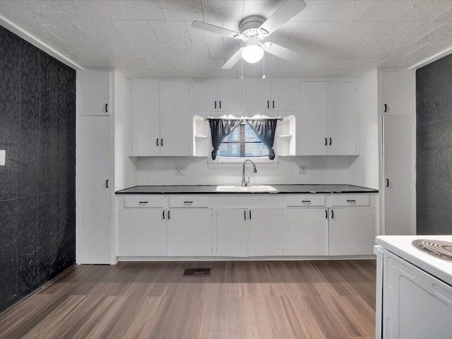 kitchen with ceiling fan, sink, white cabinets, hardwood / wood-style floors, and white stove