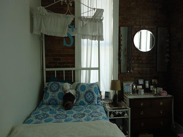 bedroom featuring brick wall