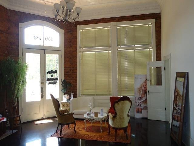 dining room with a notable chandelier, ornamental molding, a wealth of natural light, and french doors