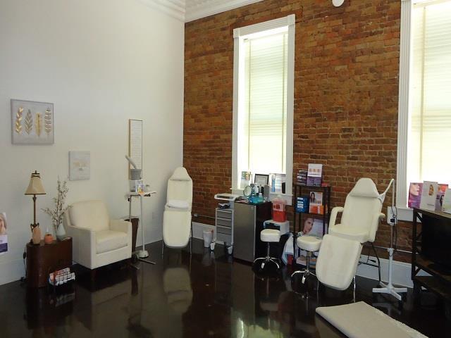 sitting room with plenty of natural light, crown molding, and brick wall