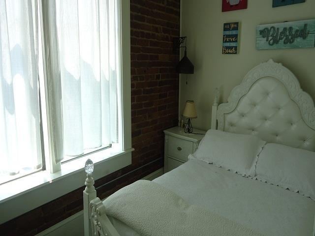 bedroom featuring brick wall