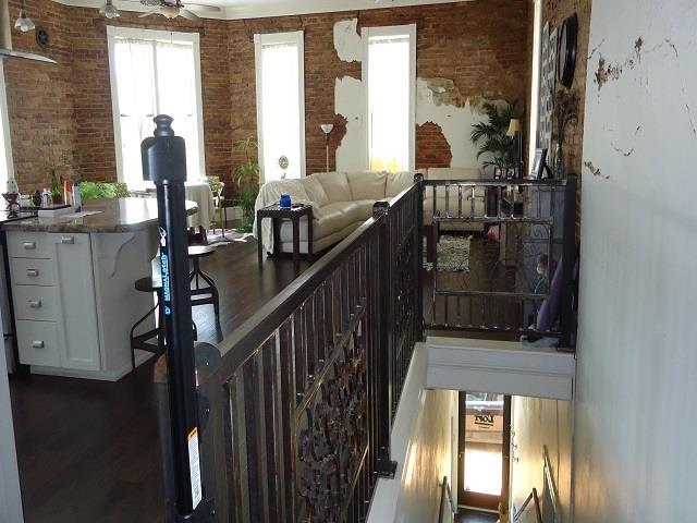 interior space with ceiling fan, brick wall, and dark hardwood / wood-style floors