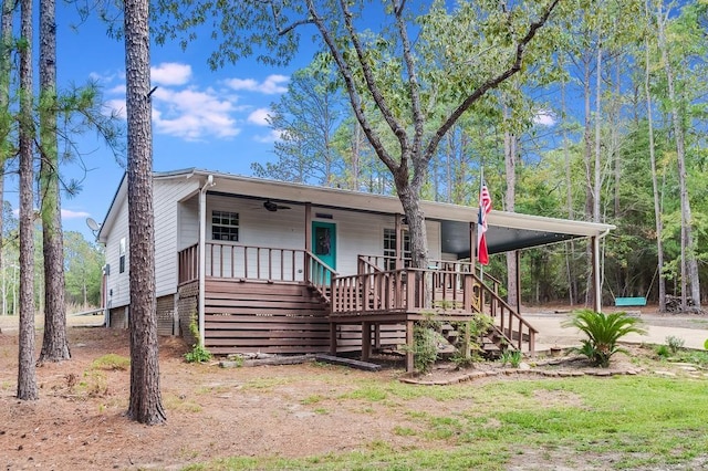 view of front facade featuring a porch, ceiling fan, stairs, and dirt driveway