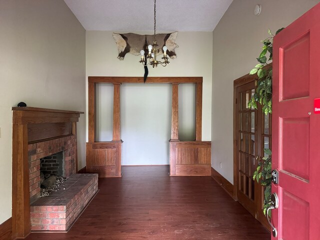 805 Worth St, Hemphill, TX 75948 - foyer entrance featuring baseboards, a notable chandelier, wood finished floors, and a fireplace