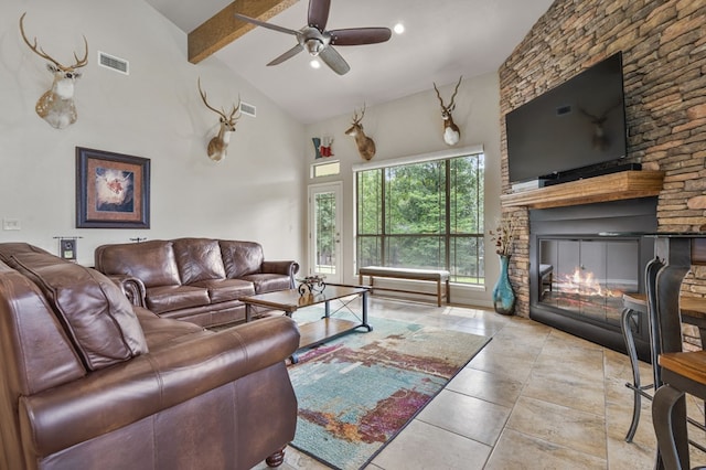 living room featuring beam ceiling, high vaulted ceiling, a stone fireplace, and ceiling fan