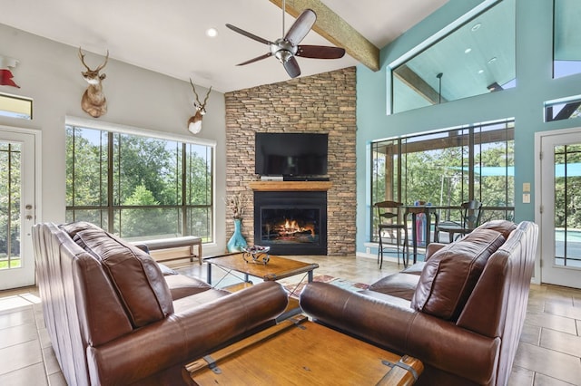 tiled living room with beamed ceiling, ceiling fan, a fireplace, and high vaulted ceiling