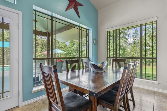 dining room featuring light tile patterned floors, a wealth of natural light, and vaulted ceiling