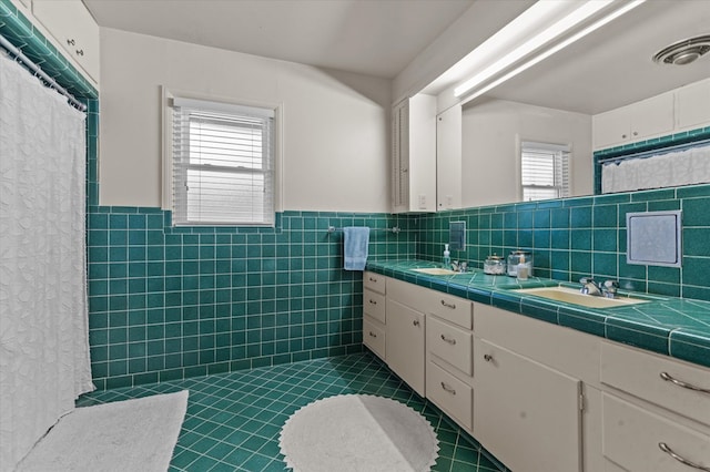 915 Evans Dr, Lufkin, TX 75904 - bathroom with tile patterned floors, tile walls, double vanity, a wainscoted wall, and curtained shower