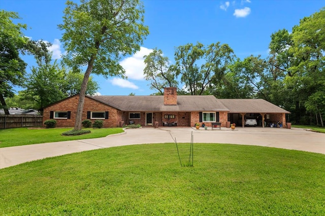 915 Evans Dr, Lufkin, TX 75904 - ranch-style home with curved driveway, a chimney, brick siding, and a carport