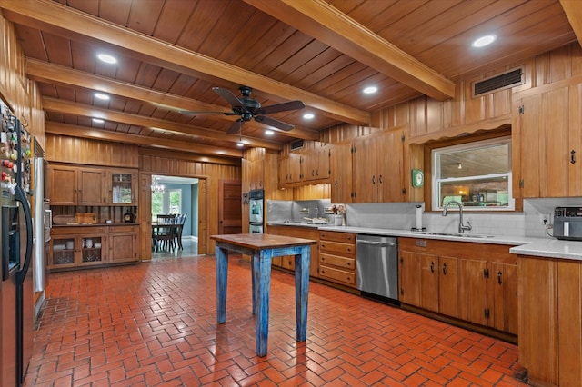 915 Evans Dr, Lufkin, TX 75904 - kitchen featuring appliances with stainless steel finishes, a wood ceiling with exposed beams, decorative backsplash, light countertops, and wooden walls