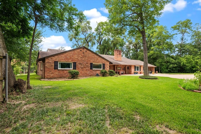 915 Evans Dr, Lufkin, TX 75904 - single story home featuring brick siding, a chimney, a front lawn, and concrete driveway