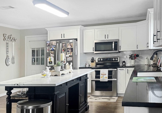 kitchen featuring a kitchen island, sink, white cabinetry, and stainless steel appliances