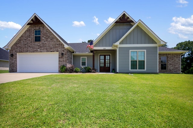 169 Shady Oaks Loop, Lufkin, TX 75904 - view of front of house featuring board and batten siding, french doors, a front lawn, concrete driveway, and brick siding