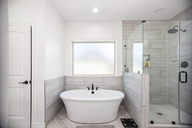 169 Shady Oaks Loop, Lufkin, TX 75904 - bathroom featuring a stall shower, a freestanding tub, tile walls, wainscoting, and recessed lighting