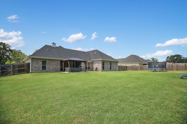 169 Shady Oaks Loop, Lufkin, TX 75904 - back of house with a trampoline, brick siding, a fenced backyard, and a gazebo