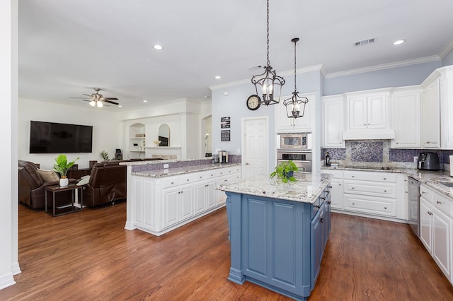 kitchen featuring a center island, white cabinets, stainless steel appliances, and ceiling fan with notable chandelier