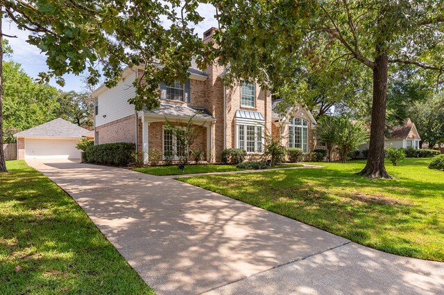 view of front of house with an outbuilding, a garage, and a front lawn