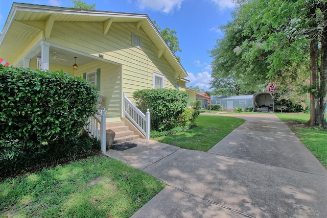 view of side of home featuring a yard and a carport