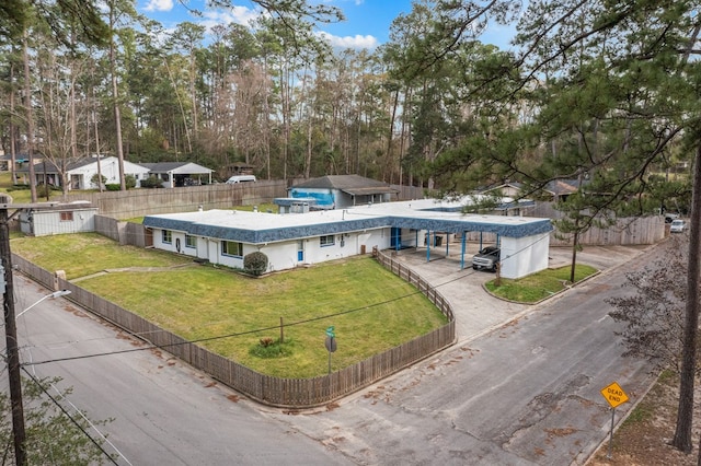 exterior space featuring a front lawn, driveway, and a fenced front yard